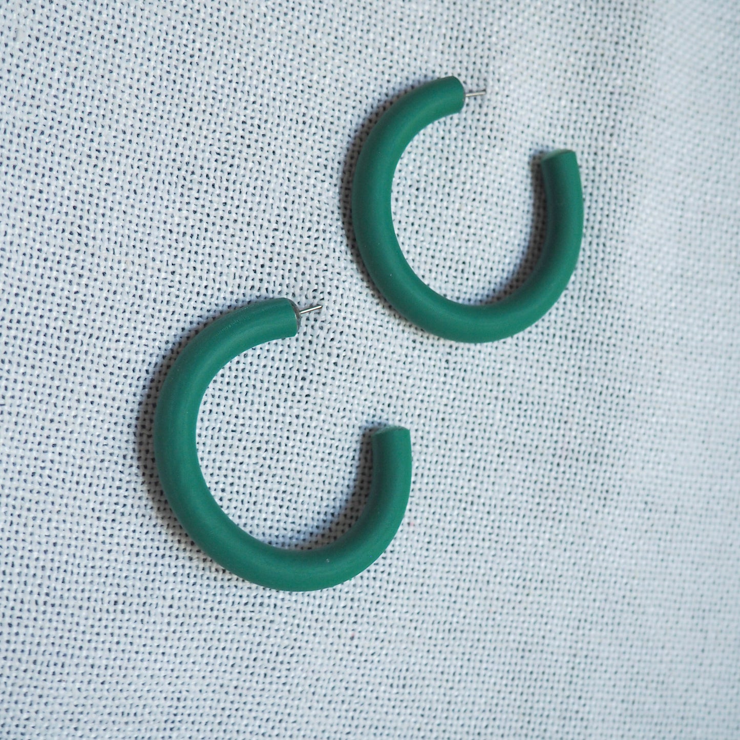 Medium emerald green hoops on white textured background