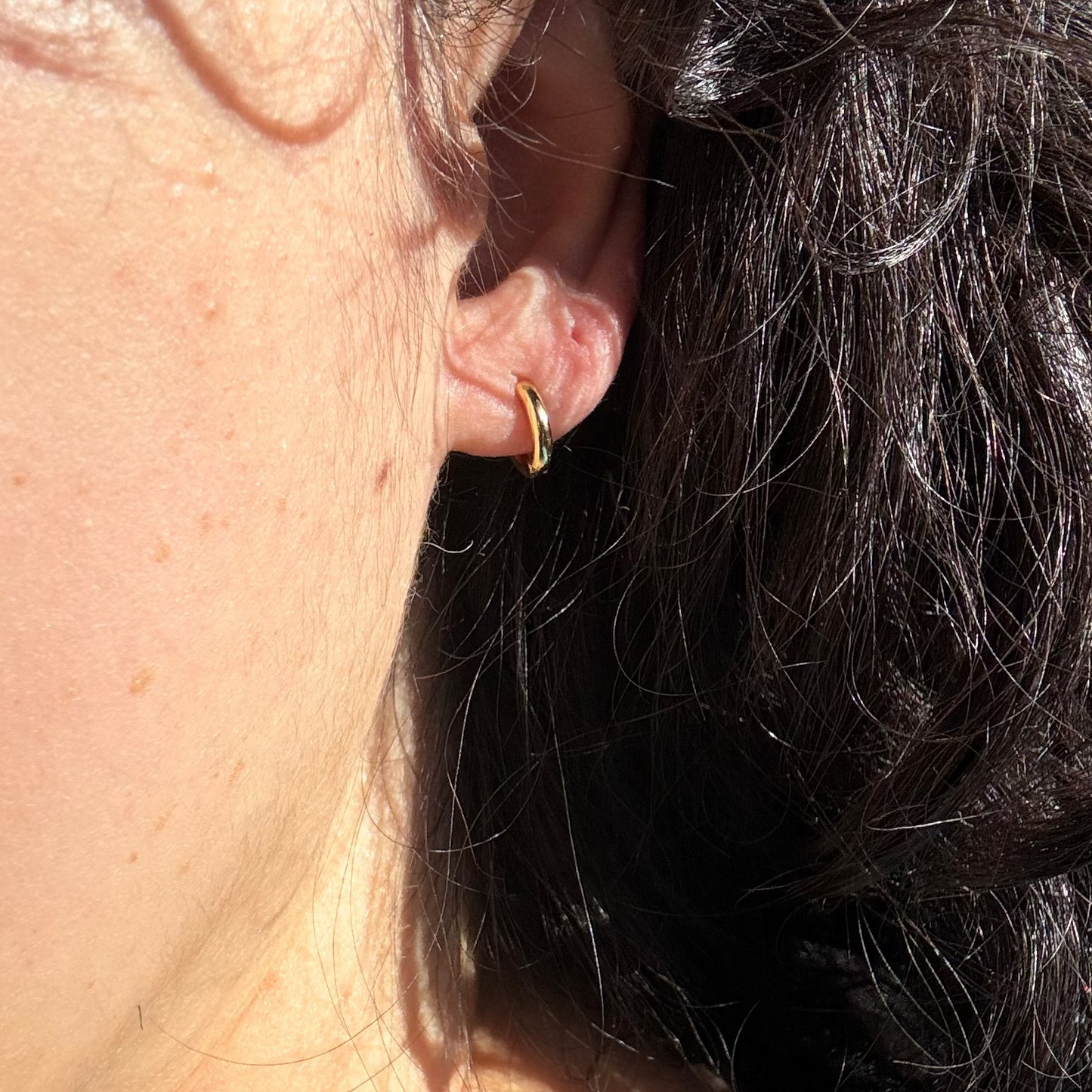 model wearing small gold filled hoop
