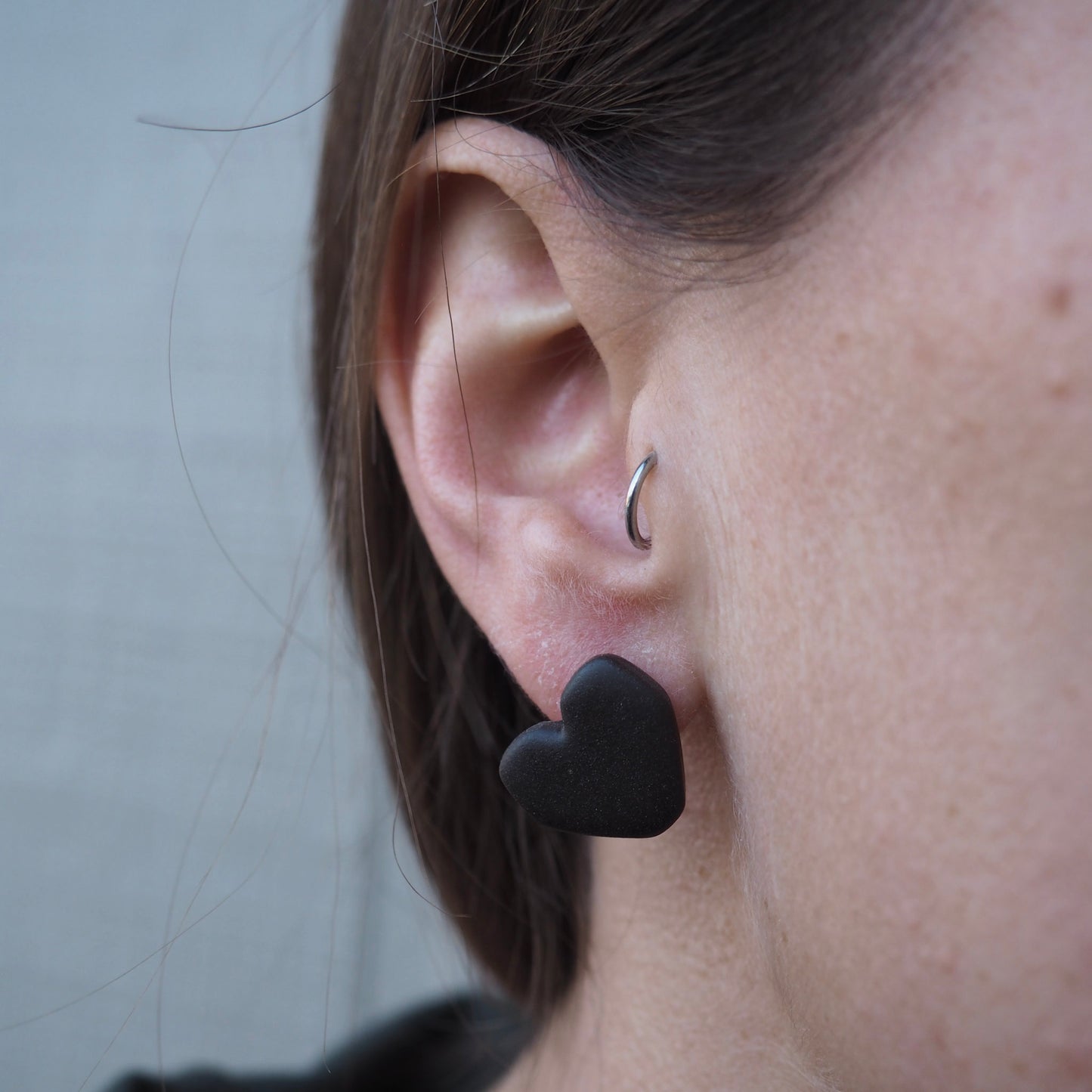 model wearing black geometric heart polymer clay studs