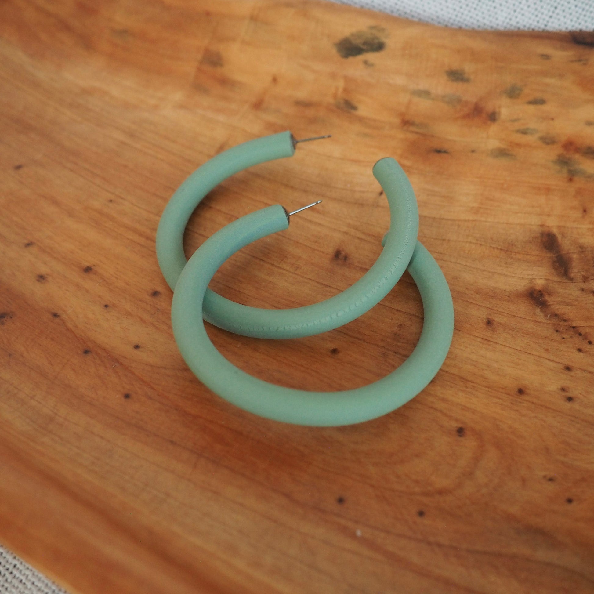 Large aloe green hoops on wood background