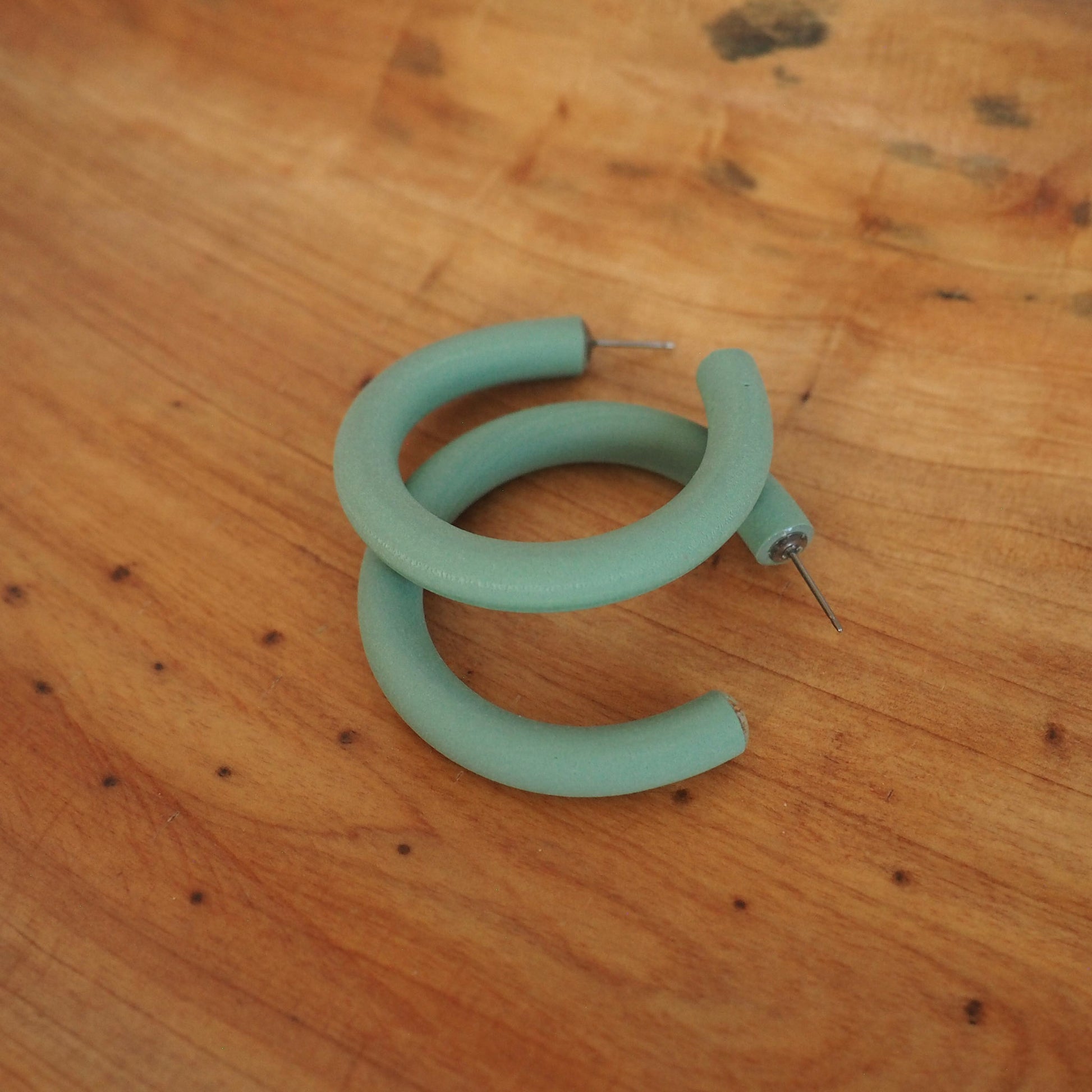 Medium aloe green hoops on wood background