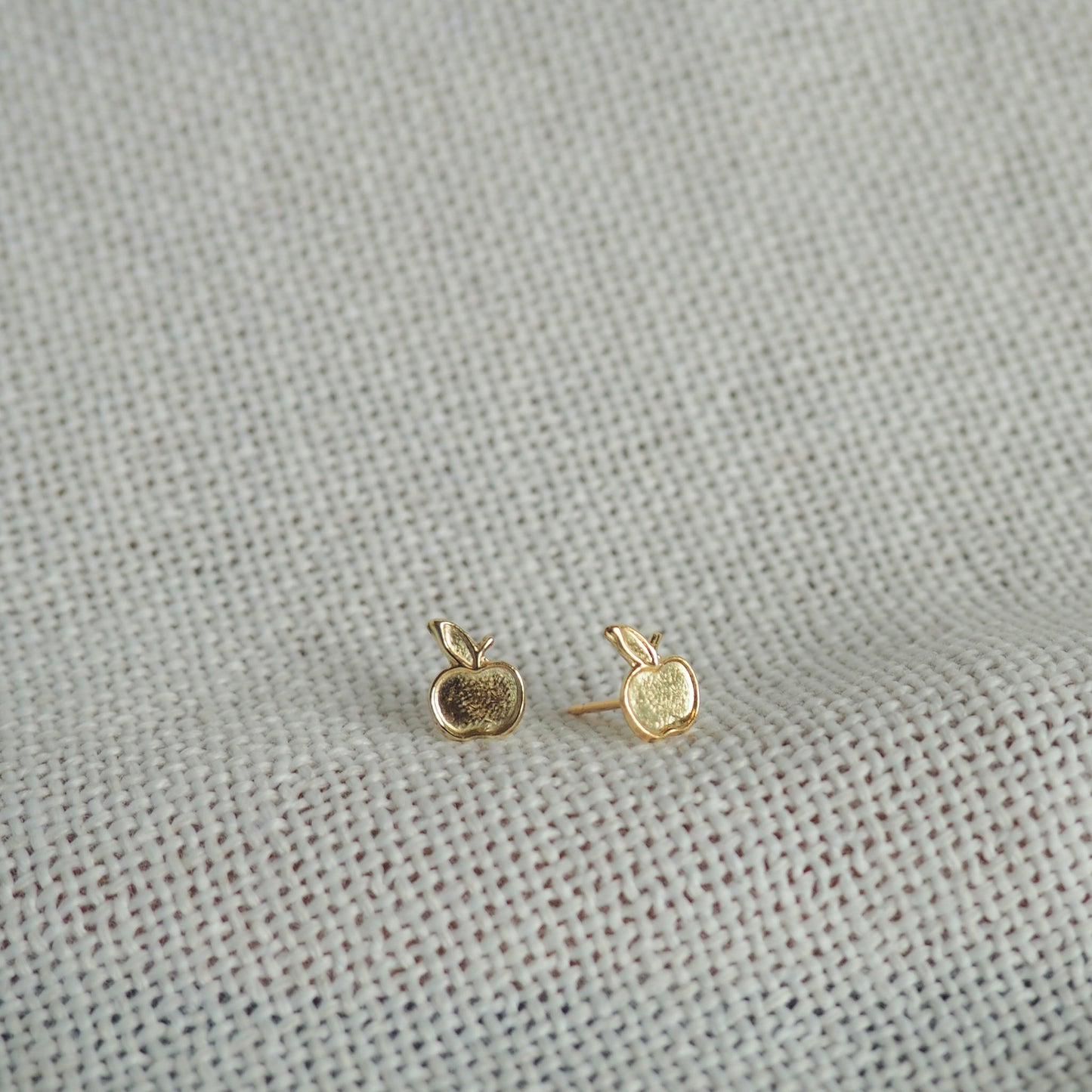 two small apple gold filled studs on a white neutral background 