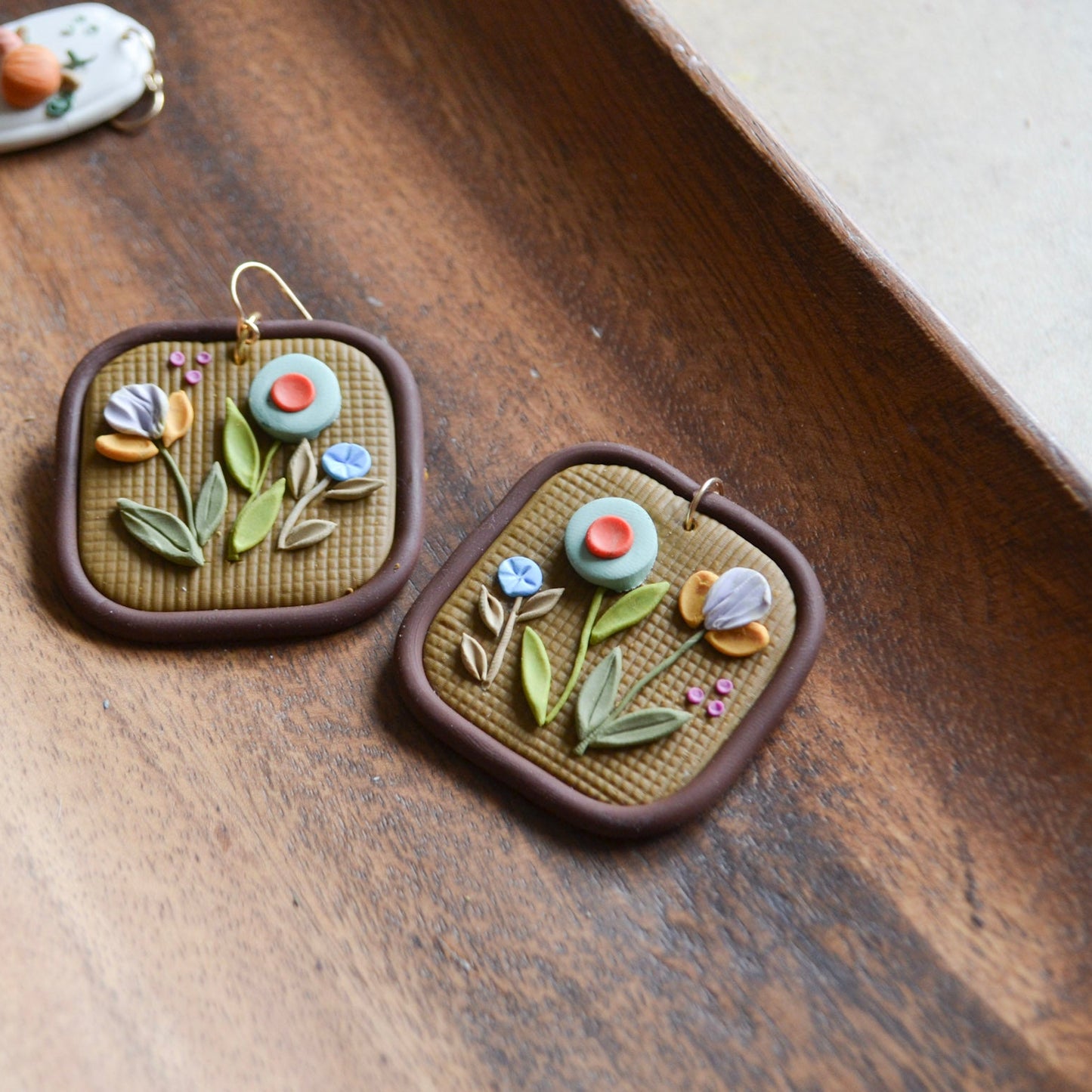 Pair of floral earrings on a wooden surface