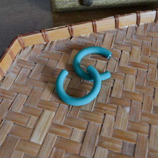 green hoop earrings with posts on woven background