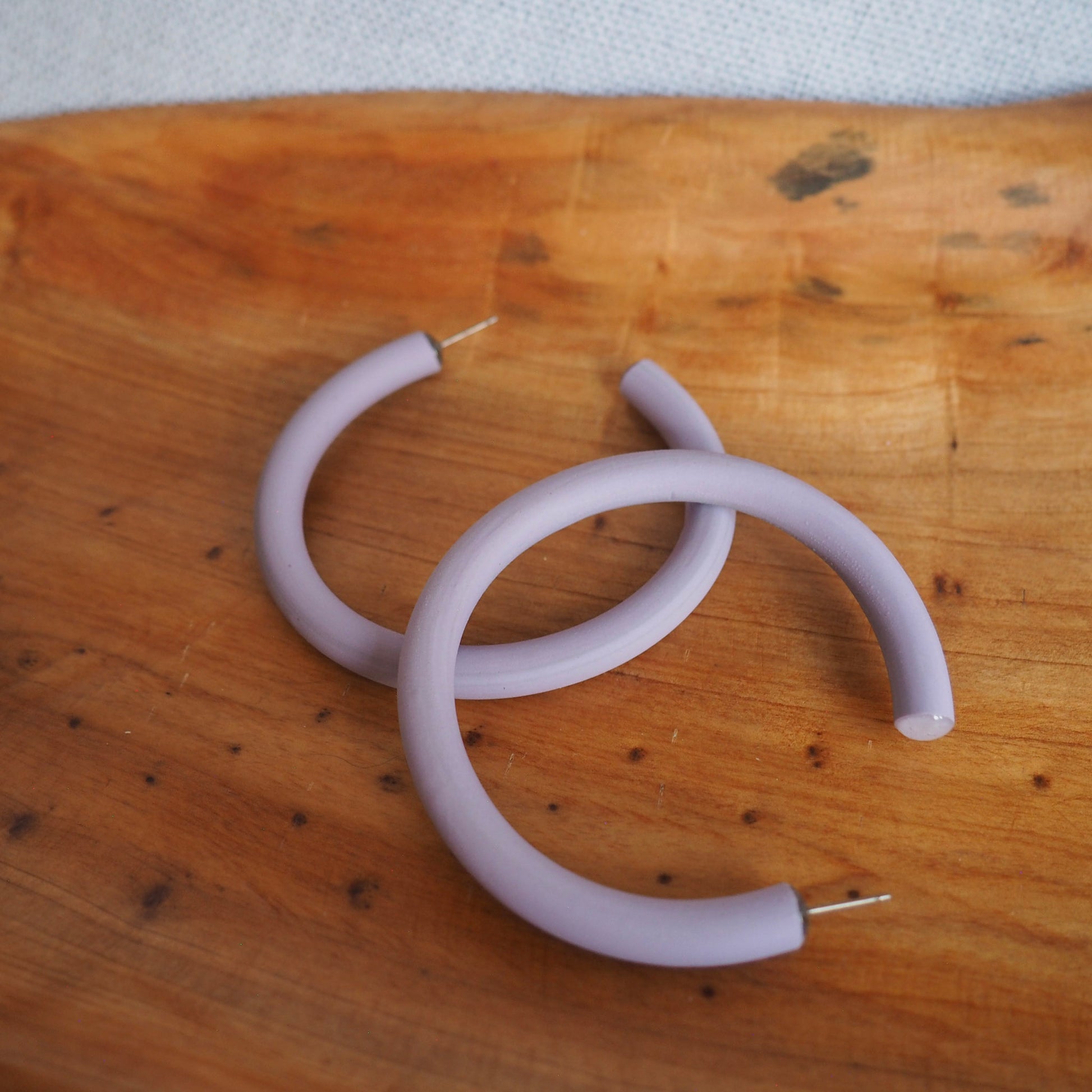 large lavender hoop earrings on wood background