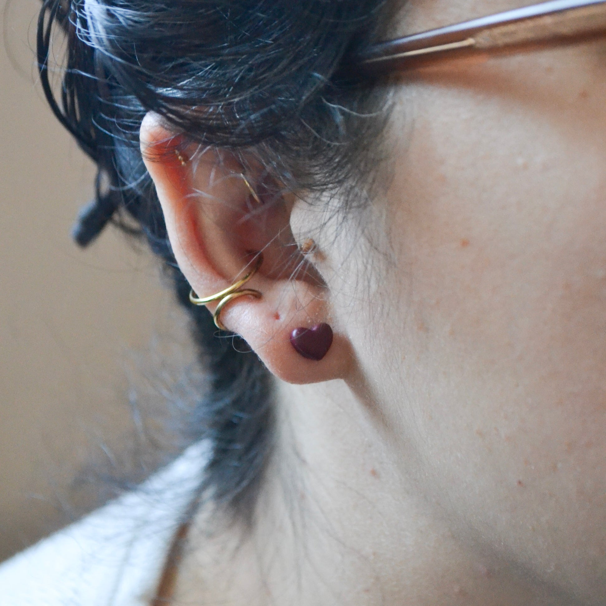 model wearing small cranberry heart polymer clay stud earrings