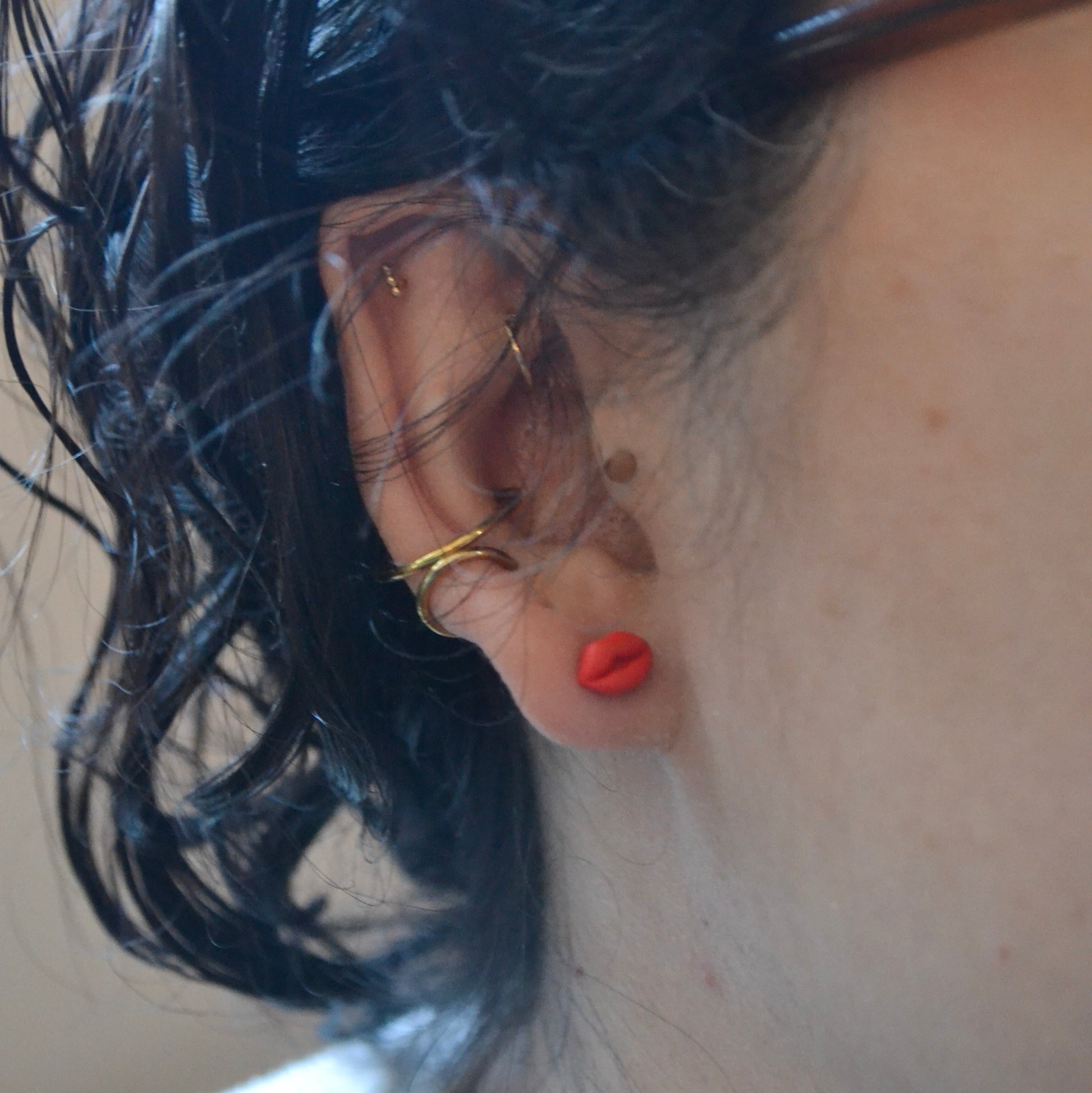 model wearing clay lip shaped stud earrings with titanium posts and backs 